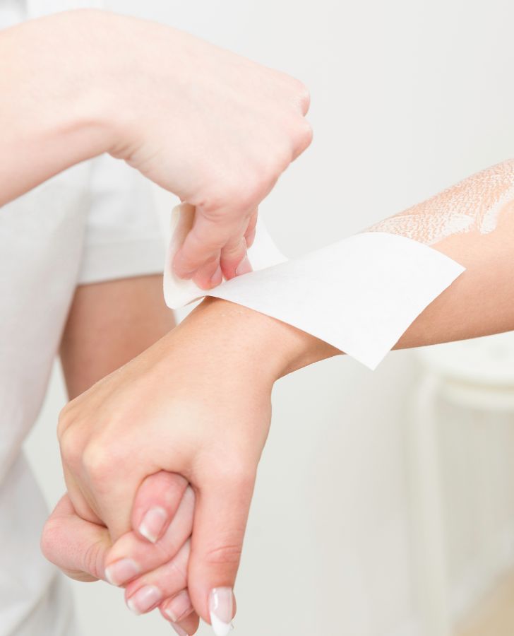 Woman Receiving Arm Waxing Treatment By A Professional